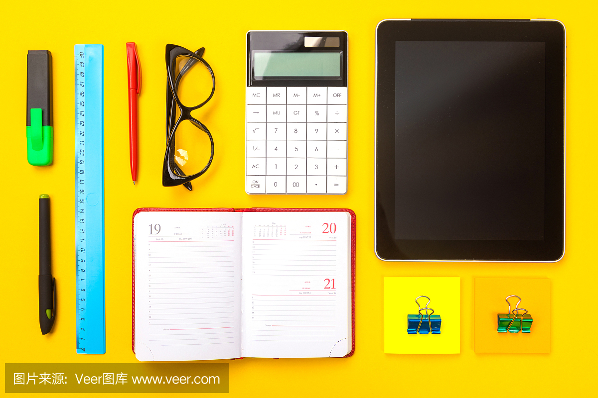 俯视图的工作空间桌子与平板电脑,笔记本和钢笔孤立在黄色背景